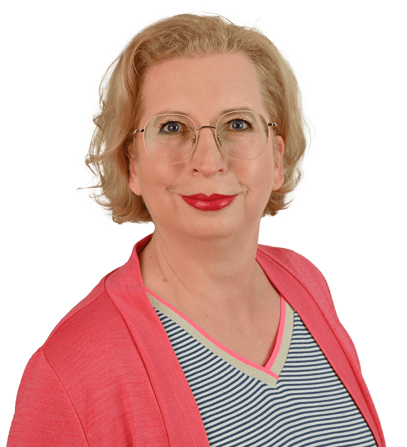 Eine lächelnde Frau mit kurzen blonden Haaren, die eine Brille trägt und einen auffälligen roten Lippenstift auf den Lippn hat.