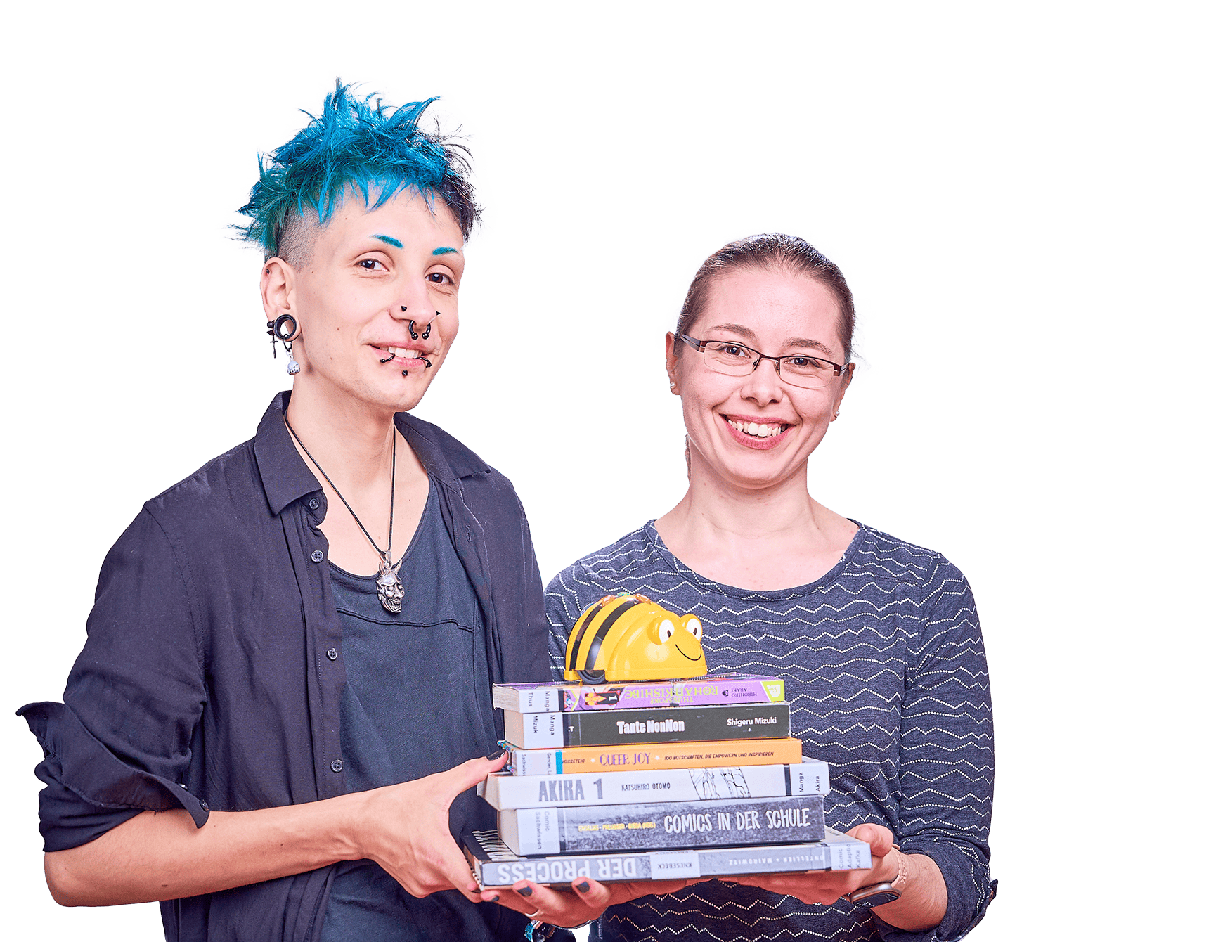 Zwei lächelnde Frauen, die gemeinsam einen Stapel Bücher in der Hand haben.