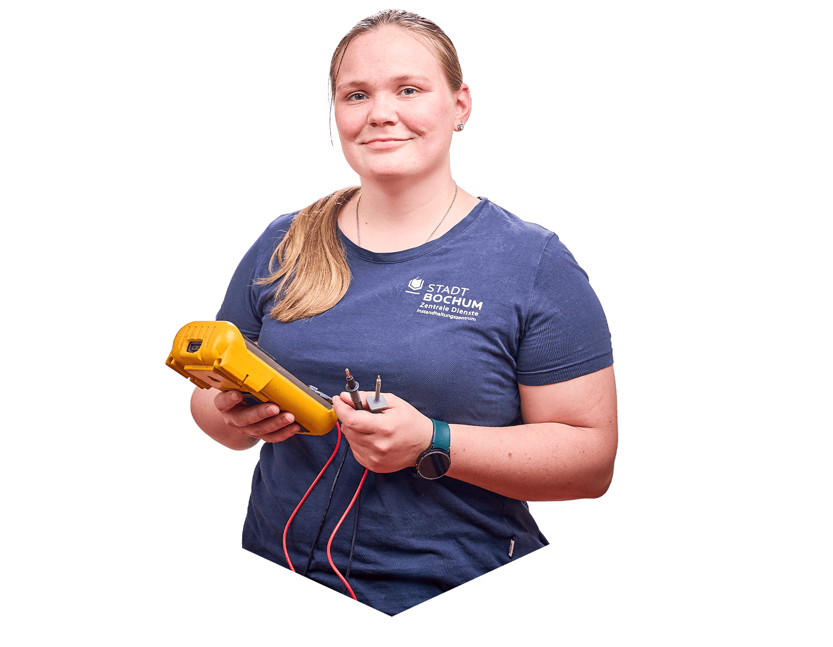 Eine Frau lächelt in die Kamera und hat ein tragbares Multimeter in beiden Händen. Sie trägt ein T-Shirt der Stadt Bochum.