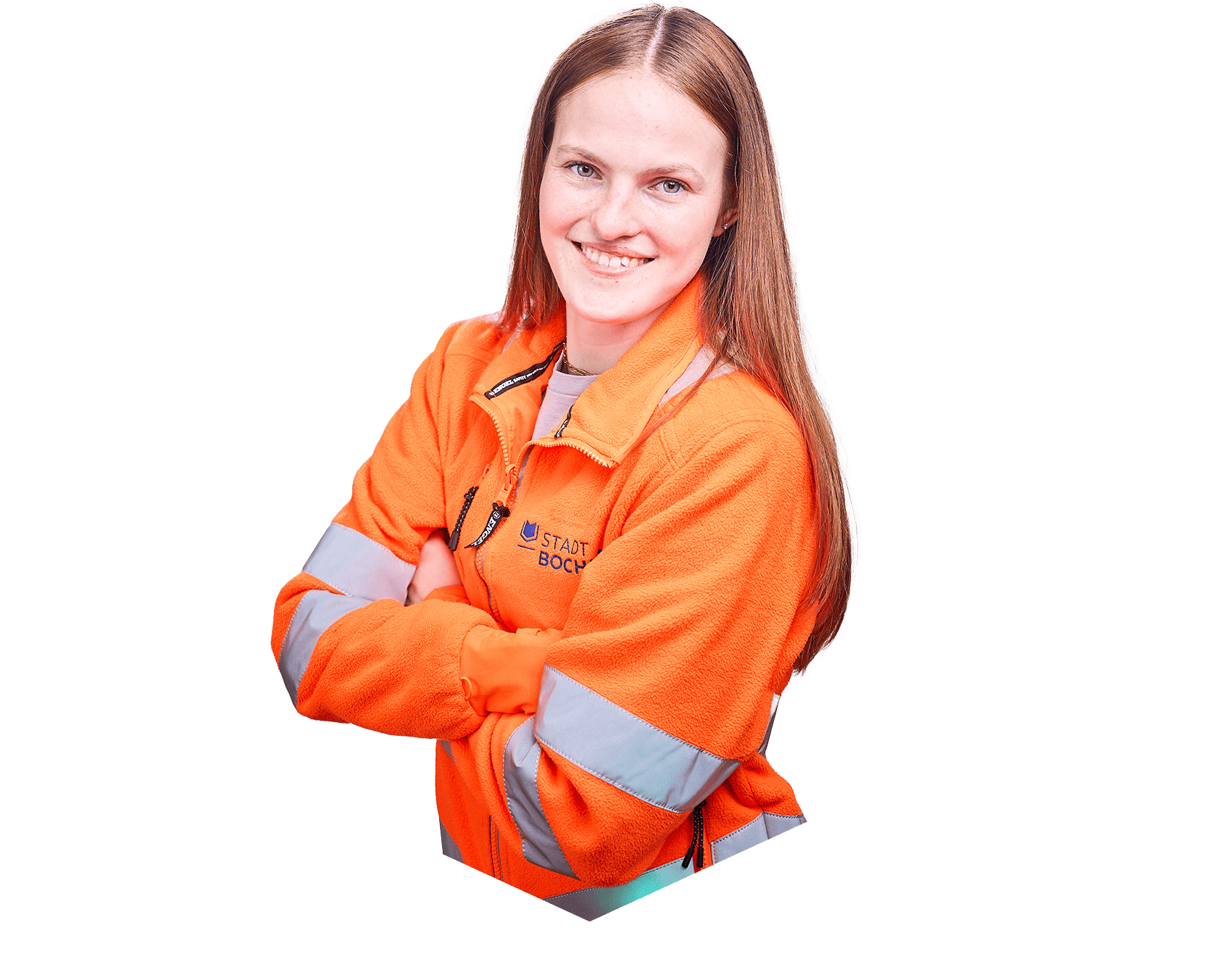 Eine Frau mit langen braunen Haaren steht mit verschränkten Armen da, lächelt freundlich in die Kamera und trägt orangefarbene Arbeitskleidung.