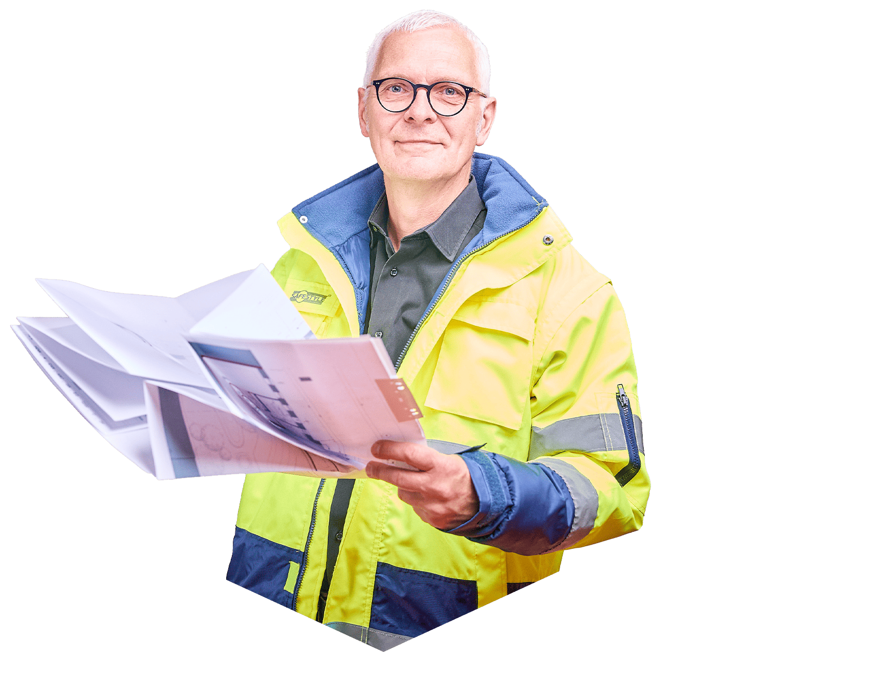 Ein Mann in Arbeitskleidung lächelt in die Kamera, während er mehrere Zettel in der Hand hält.