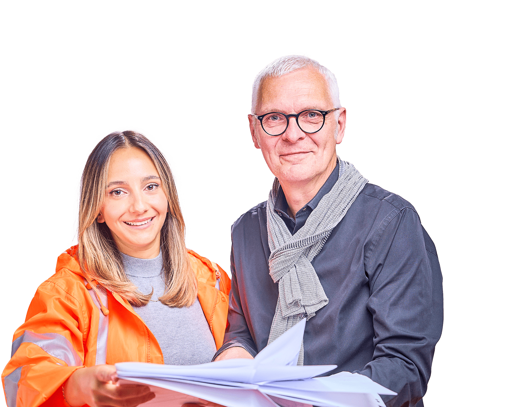 Eine Frau und eine Mann lächeln in die Kamera, während sie Papierzettel in der Hand halten.