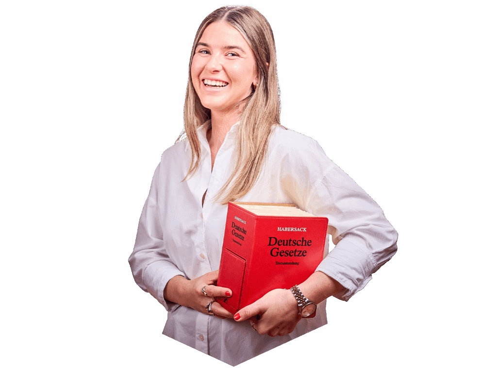 Eine Frau mit langen blonden Haaren lächelt in die Kamera und hat das rote deutsche Gesetzbuch in der Hand.