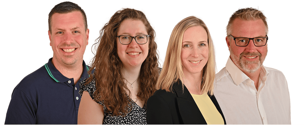 Zwei Frauen und zwei Männer, die gemeinsam in die Kamera lächeln.