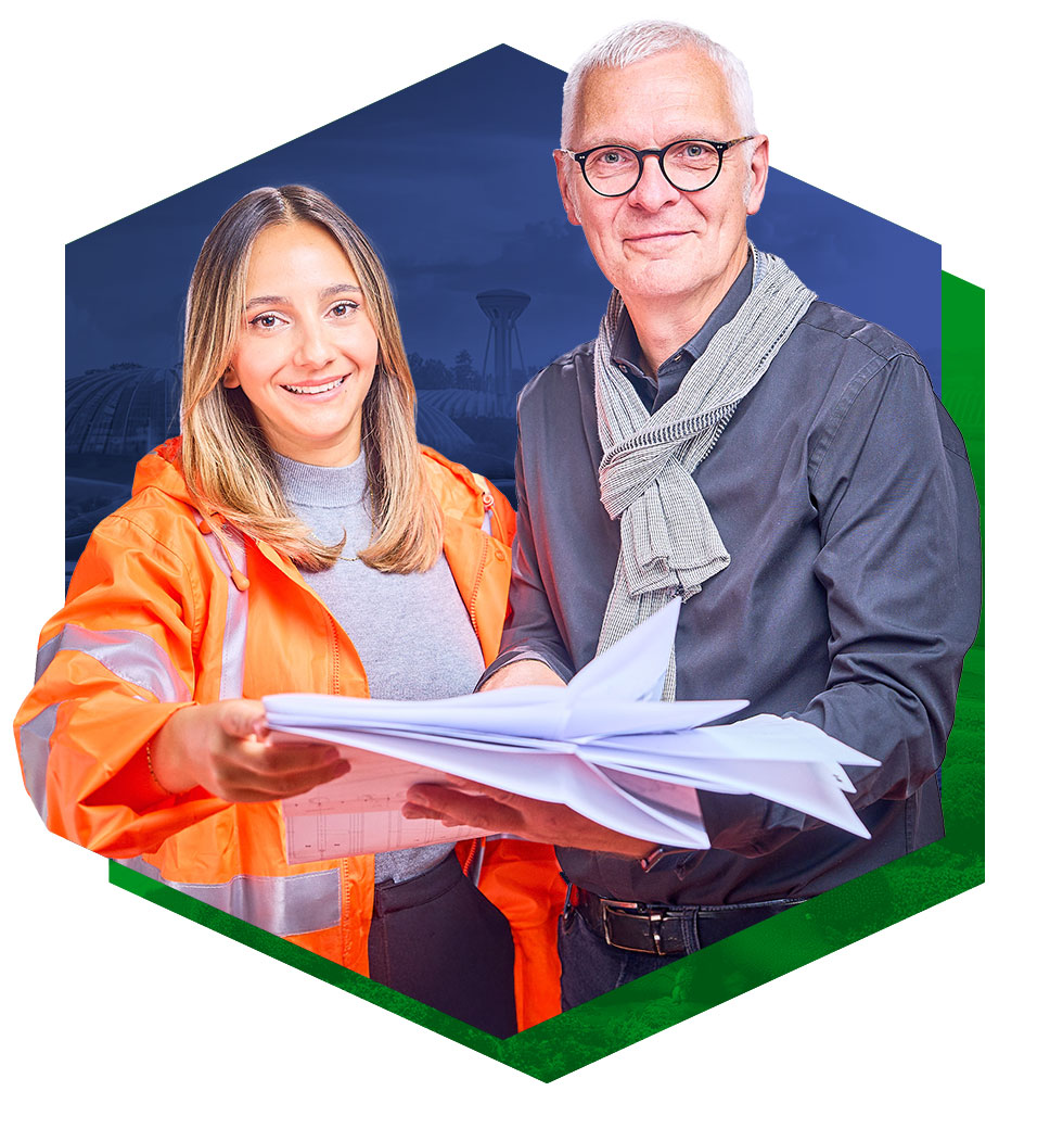 Eine Frau und ein Mann, die gemeinsam in die Kamera lächeln und mehrere Zettel in den Händen halten.