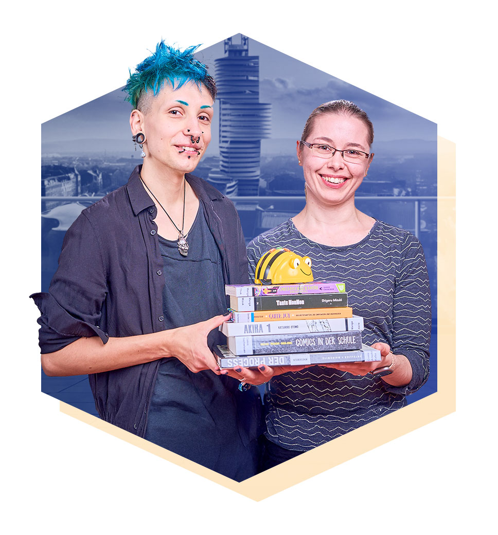 Zwei lächelnde Frauen, die gemeinsam mehrere Bücher in den Händen halten.