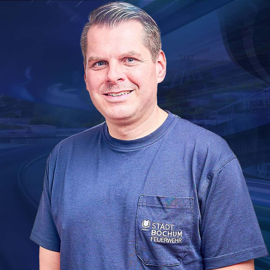 Lächelnder Mann mit einem blauem T-Shirt von der Stadt Bochum.