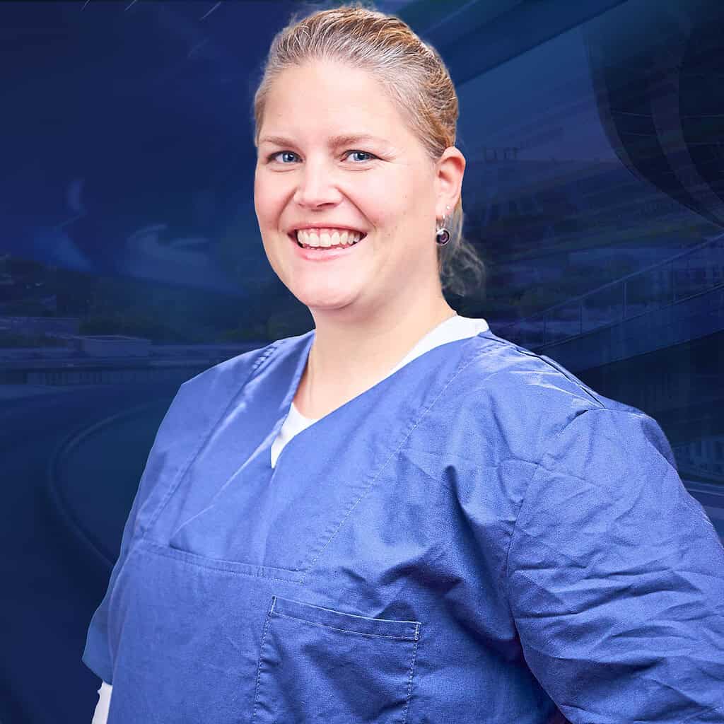 Lächelnde Krankenschwester in einem blauen Kittel.