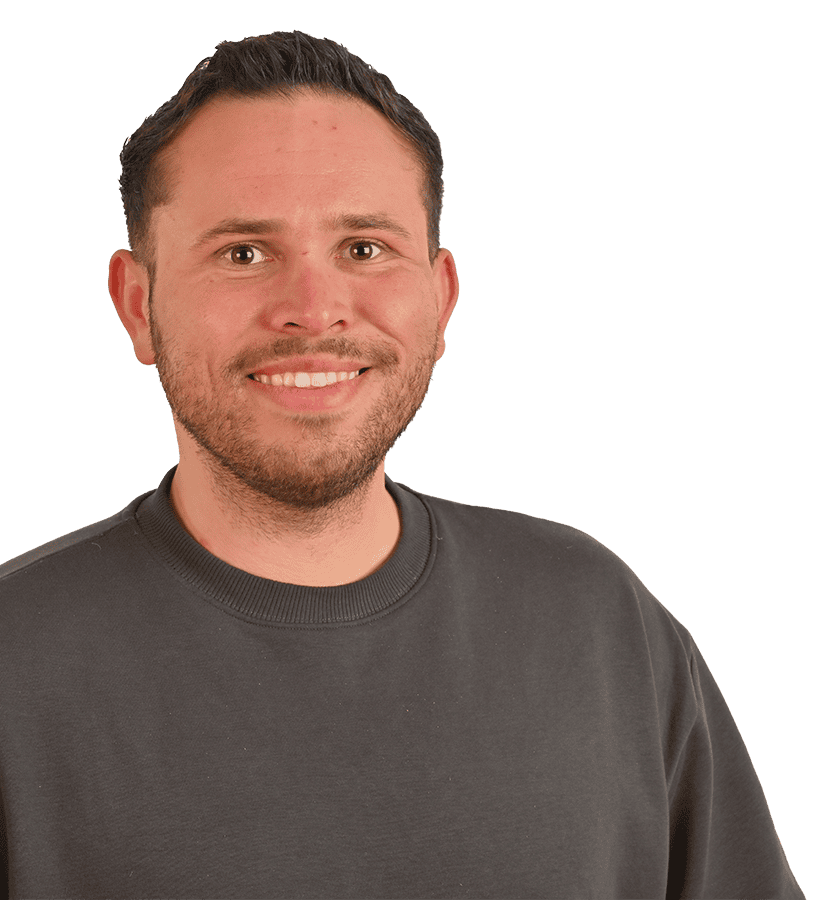 Ein lächelnder Mann, der einen grauen Pullover trägt.