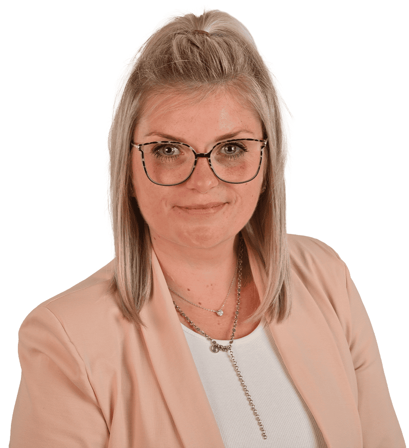 Eine lächelnde Frau, die einen rosafarbenen Blaser und eine Brille trägt.