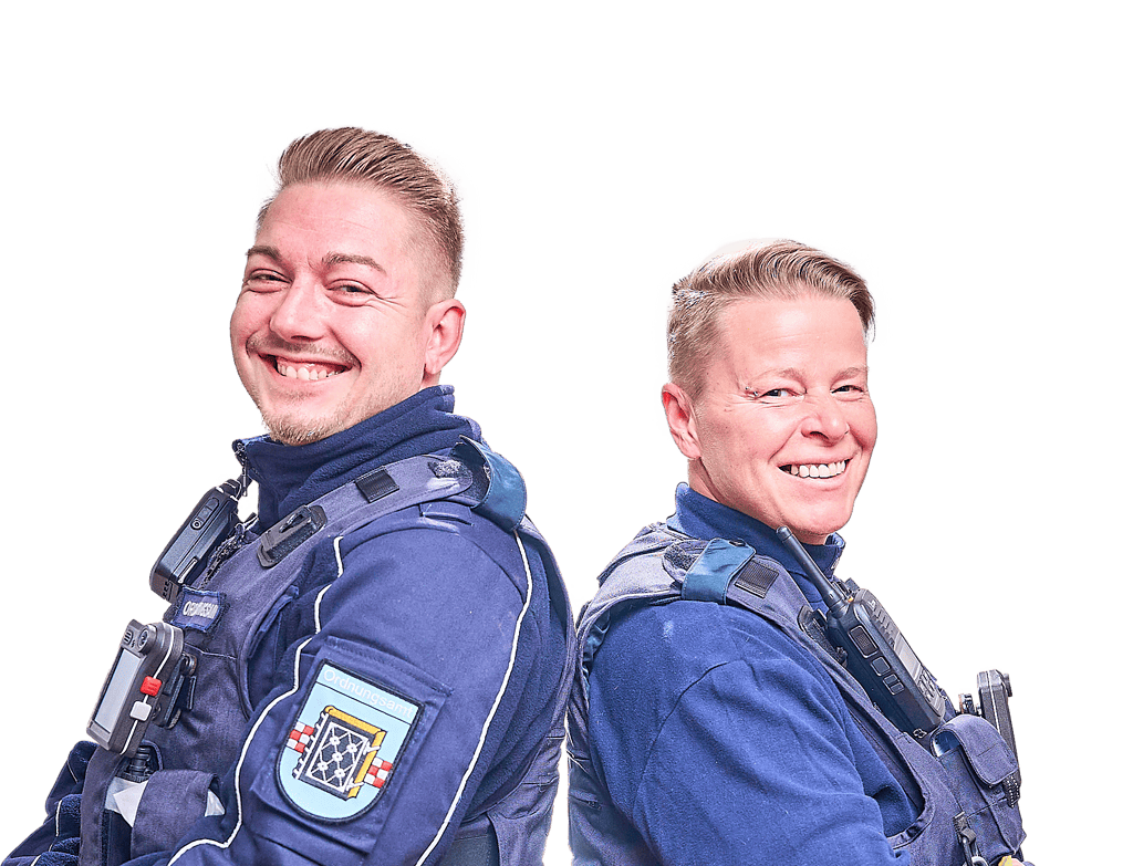 Eine Frau und ein Mann stehen Rücken an Rücken und schauen lächelnt in die Kamera.