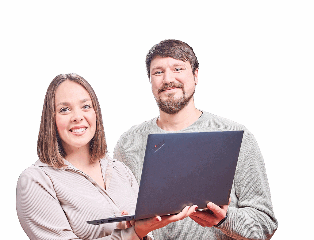 Eine Frau und ein Mann schauen lächelnt in die Kamera und haben einen Laptop in der Hand.