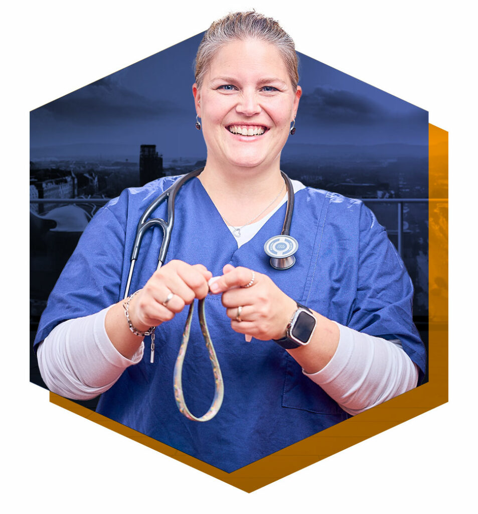 Lächende Ärztin mit blauen Kittel und einem Stethoskop um den Hals