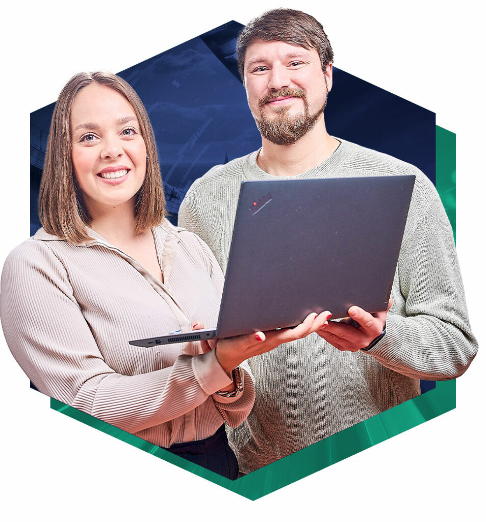 Ein lächender Mann und eine lächende Frau halten gemeinsam einen Laptop in der Hand.