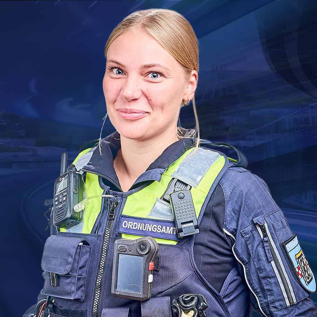 Eine Frau in Arbeitskleidung vom Ordnungsamt schaut lächelnt in die Kamera.