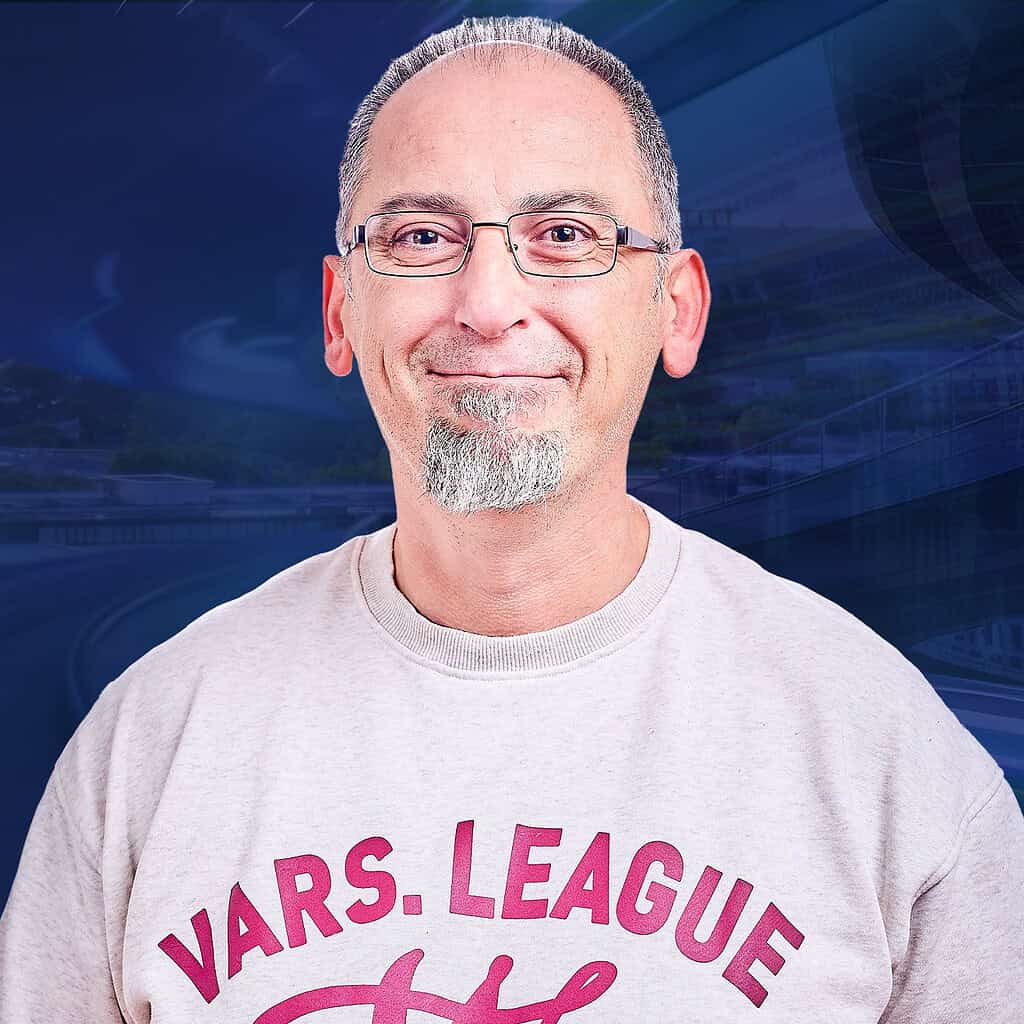 Ein freundlicher Mann mit Brille und Bart steht vor einem blauen Hintergrund mit futuristischen Details.