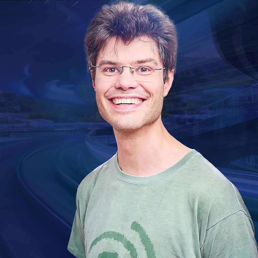 Lächender Mann mit Brille und grünem T-Shirt.