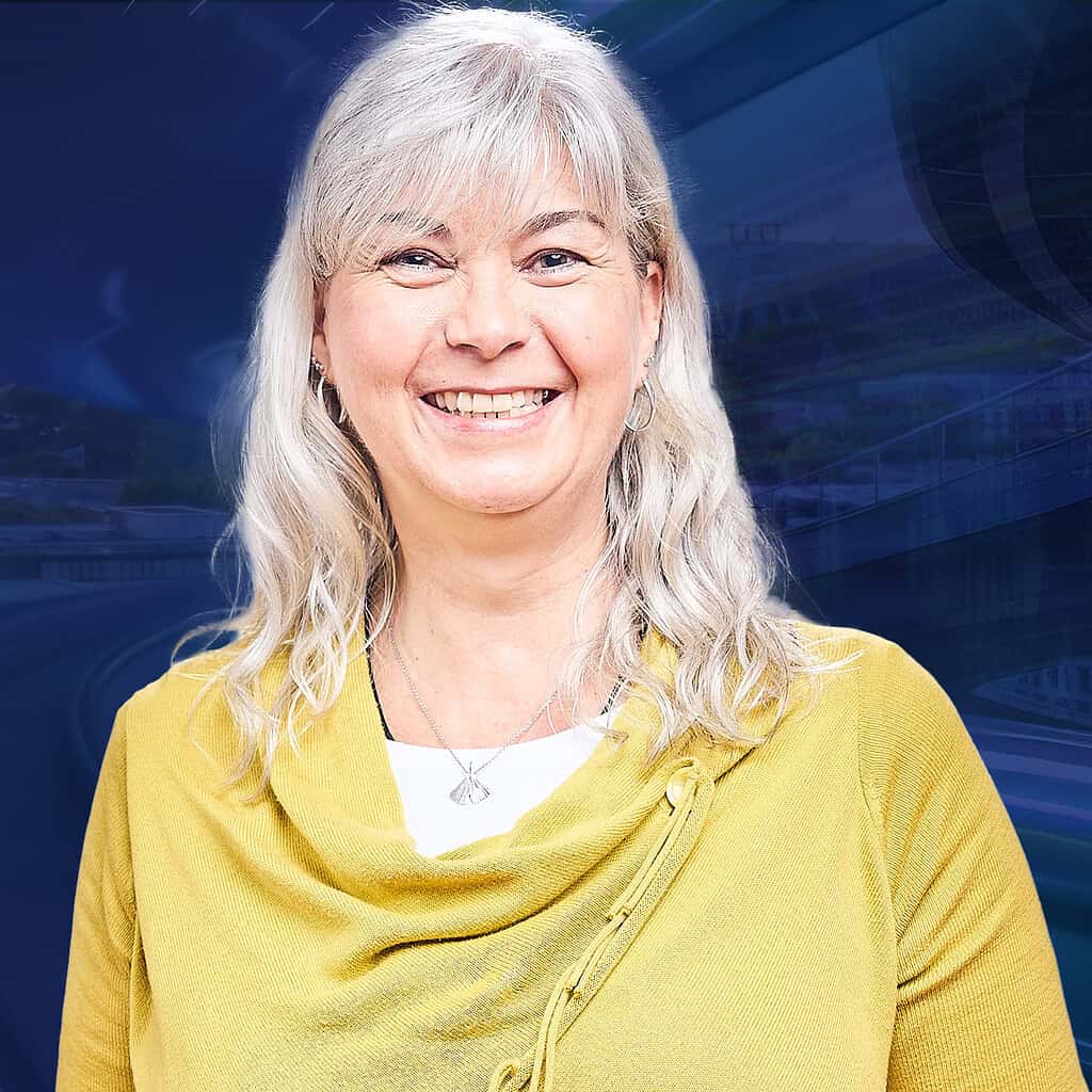 Lächelnde ältere Frau in einem gelben Pullover.