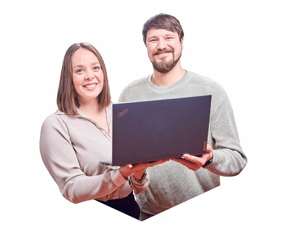 Eine Frau und ein Mann, die lächelnd in die Kamera schauen und gemeinsam einen Laptop in den Händen halten.