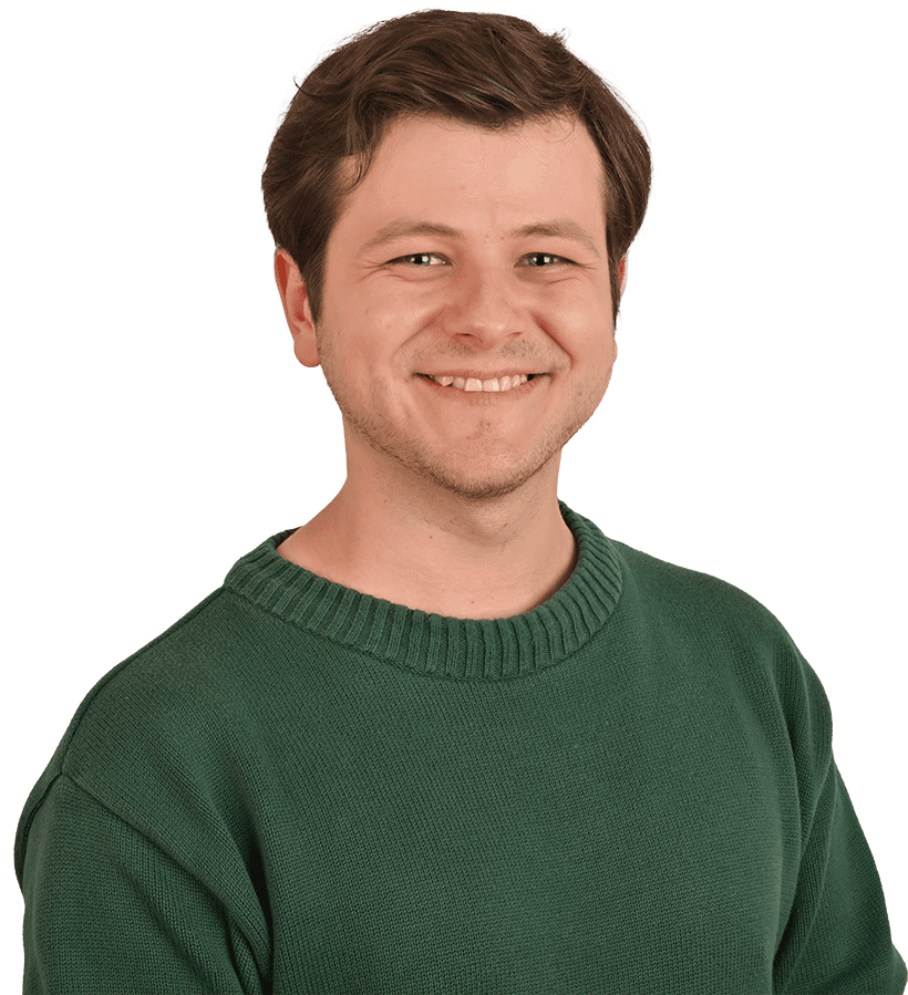 Ein lächelnder junger Mann mit einem grünen Pullover.